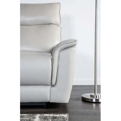 Beige leather recliner chair with a modern design on a wooden floor.