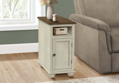 Small end table with a brown top next to a gray recliner in a living room.