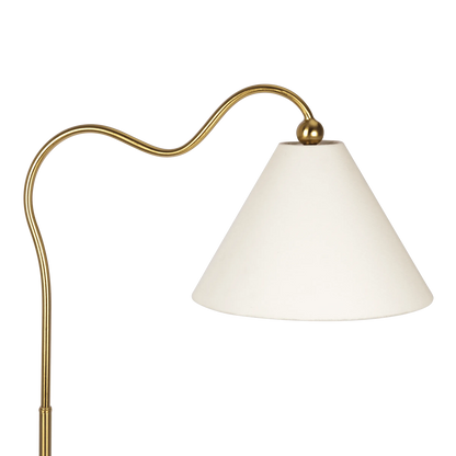 Floor lamp with gold curved arm and white shade on a white background