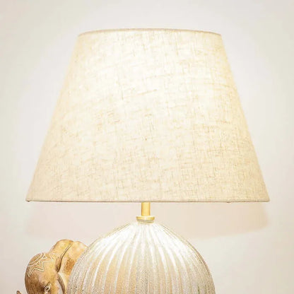 Decorative lamp with a textured base and beige lampshade on a light background